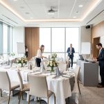 Une équipe composée de deux femmes et de deux hommes prépare un événement d’entreprise dans une salle moderne et lumineuse.